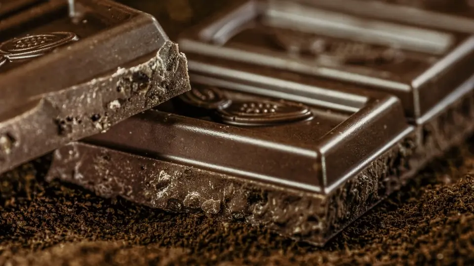 Een tablet donkere chocolade tegen een zwarte ondergrond