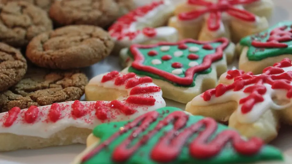 Kerstkoekjes met rode versiering op een plateau